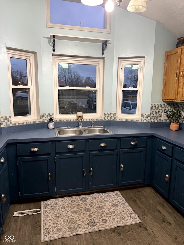 interior space featuring vaulted ceiling, dark hardwood / wood-style floors, sink, and tasteful backsplash