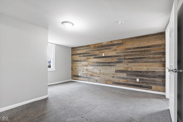 empty room featuring wood walls and dark colored carpet