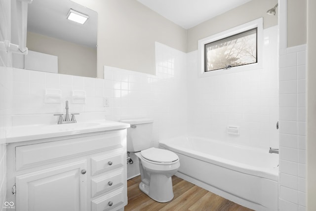 full bathroom with hardwood / wood-style flooring, tub / shower combination, tile walls, vanity, and toilet