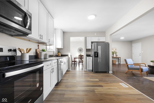 kitchen featuring white cabinetry, stainless steel appliances, sink, and hardwood / wood-style floors