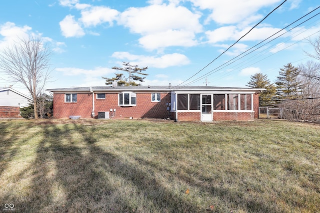 back of property featuring a sunroom, central AC unit, and a lawn