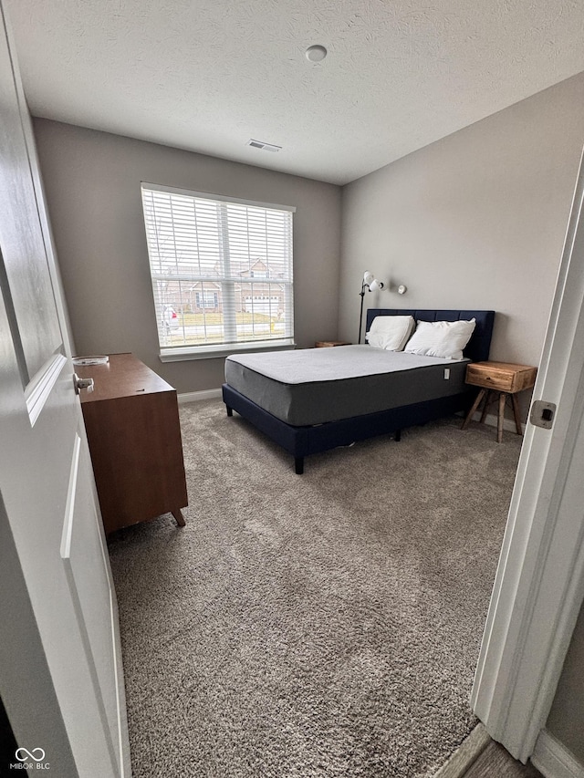 carpeted bedroom featuring a textured ceiling