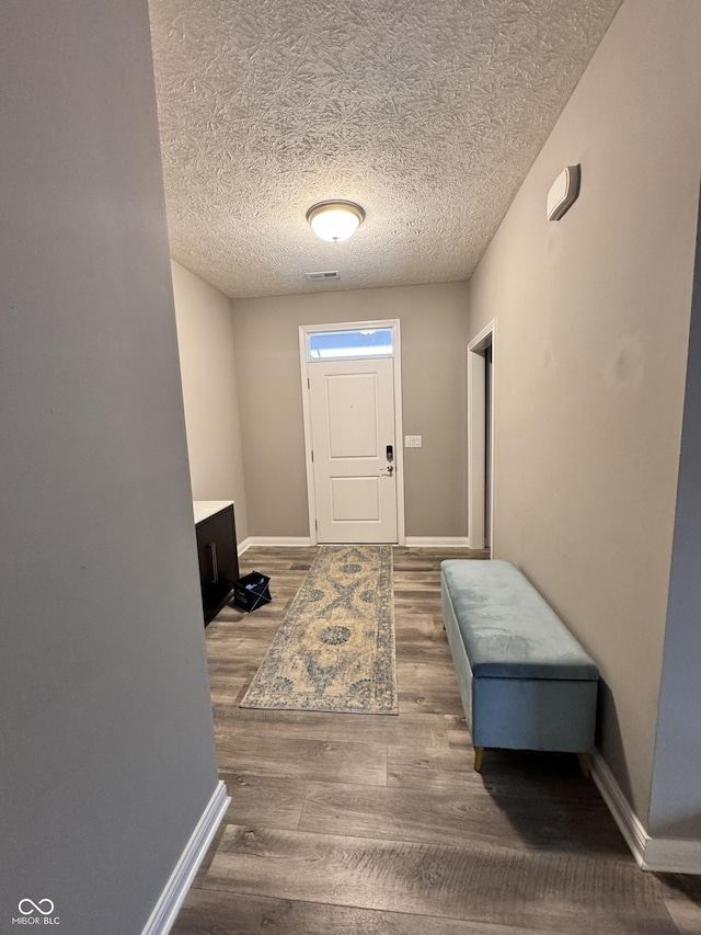 foyer entrance with hardwood / wood-style flooring and a textured ceiling