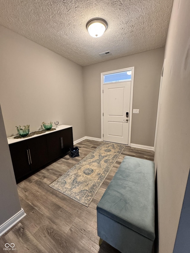 entrance foyer with dark hardwood / wood-style floors and a textured ceiling