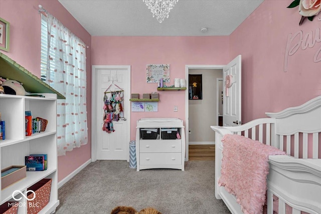 bedroom with a textured ceiling, baseboards, light colored carpet, and a notable chandelier