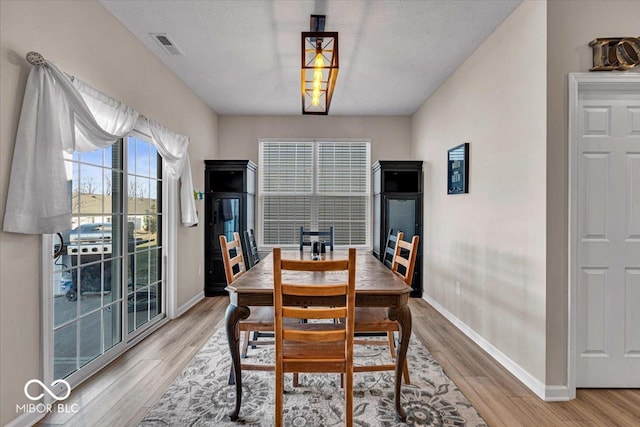 dining room featuring visible vents, baseboards, and wood finished floors