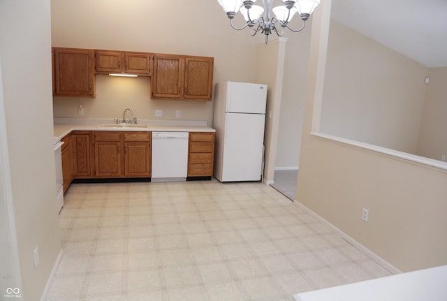 kitchen with a towering ceiling, decorative light fixtures, sink, a notable chandelier, and white appliances