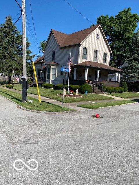 view of front of home with a front yard and covered porch