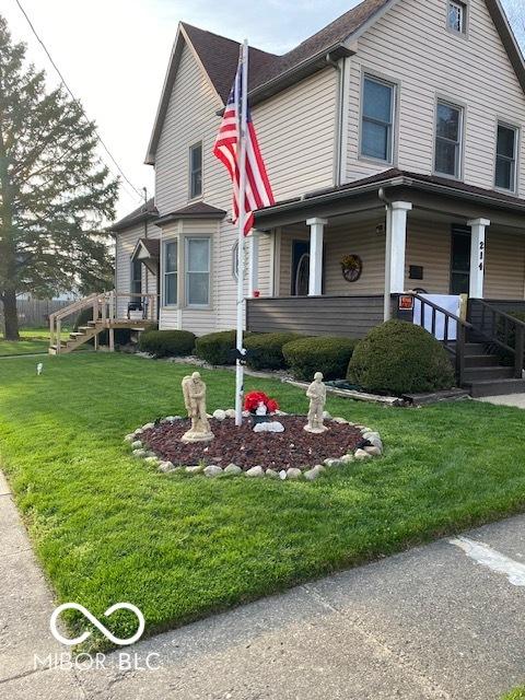 view of front of house with a porch and a front yard