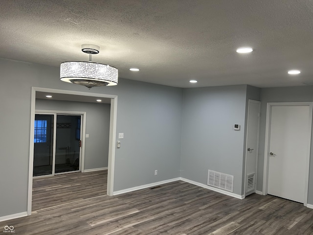 unfurnished room featuring dark hardwood / wood-style floors and a textured ceiling