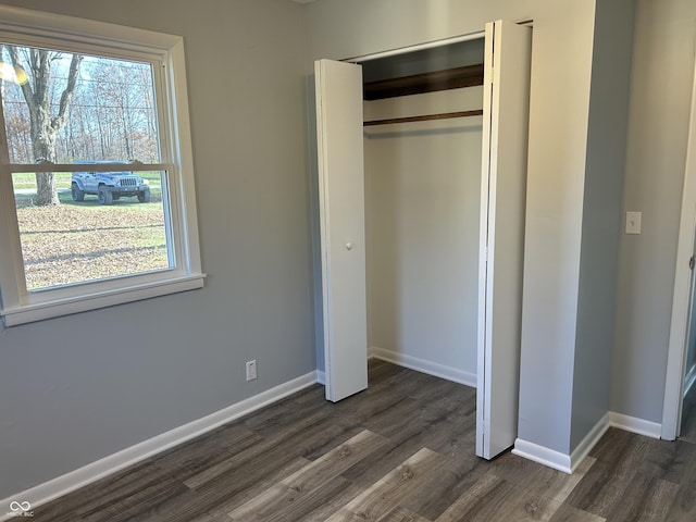 unfurnished bedroom featuring dark wood-type flooring and a closet