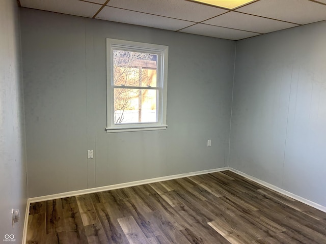 empty room with wood-type flooring and a drop ceiling