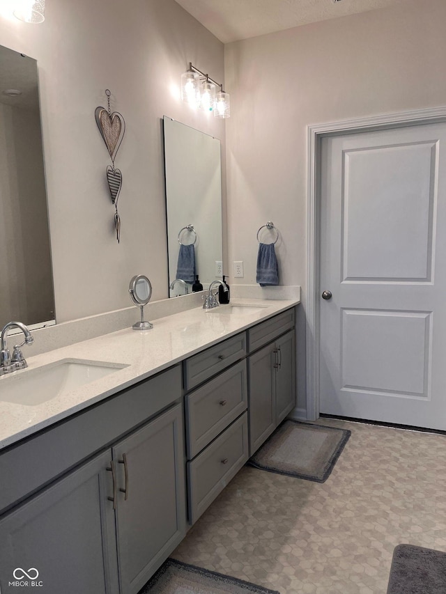 full bath featuring double vanity, a sink, and tile patterned floors