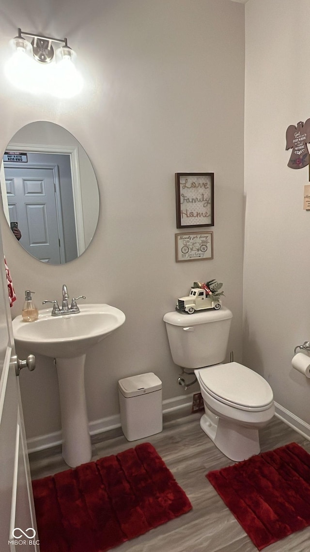 bathroom featuring wood finished floors, toilet, and baseboards