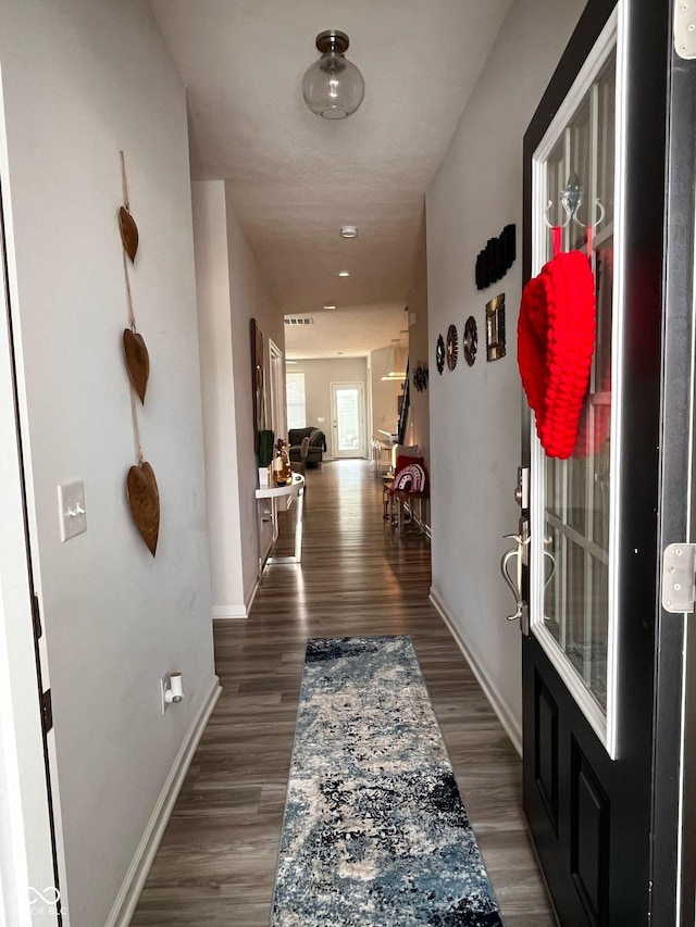 hallway with baseboards and wood finished floors