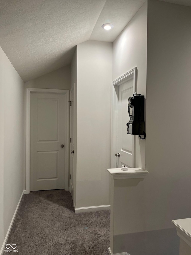 bathroom with vaulted ceiling, a textured ceiling, and baseboards