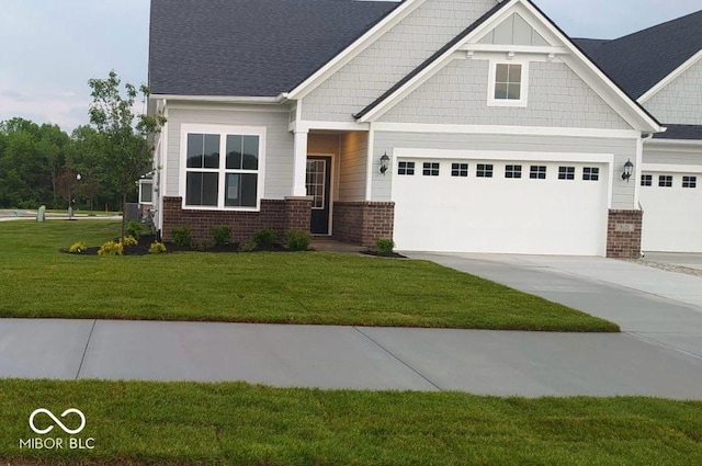 craftsman-style home with an attached garage, driveway, brick siding, and a front yard