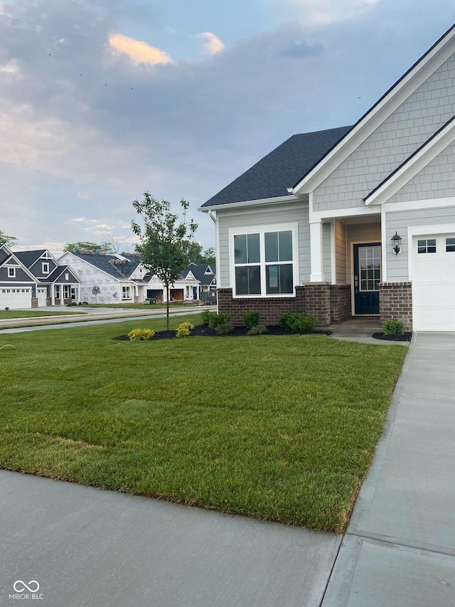 view of front of property with a front yard, brick siding, and a residential view