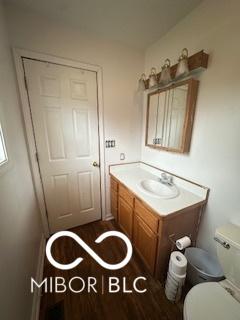 bathroom featuring hardwood / wood-style flooring, vanity, and toilet