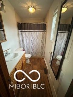 bathroom with hardwood / wood-style flooring, vanity, a shower with shower curtain, and toilet