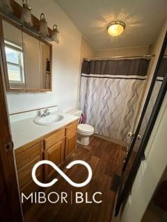 bathroom featuring hardwood / wood-style flooring, vanity, curtained shower, and toilet