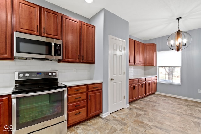 kitchen featuring pendant lighting, appliances with stainless steel finishes, tasteful backsplash, and a notable chandelier