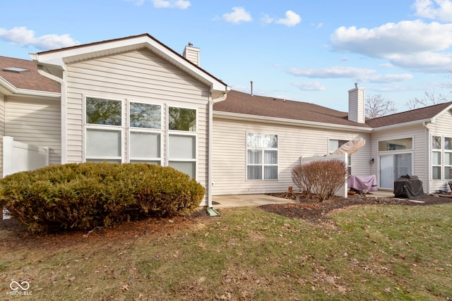 rear view of property featuring a patio area and a lawn