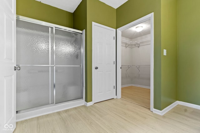 bathroom with hardwood / wood-style floors and a shower with door