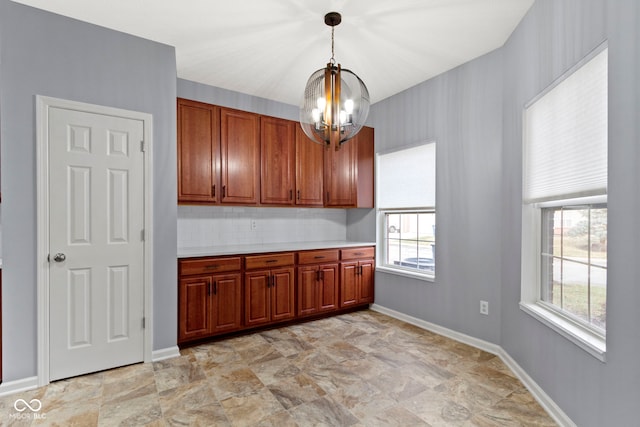 kitchen featuring decorative backsplash, hanging light fixtures, and a notable chandelier