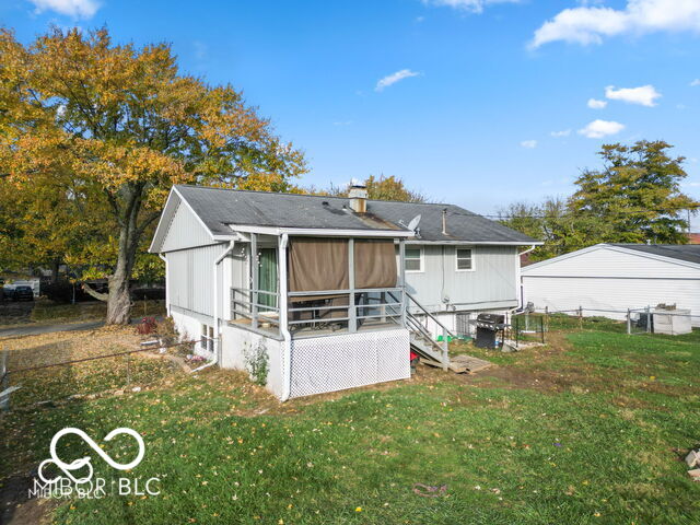 rear view of house featuring a lawn