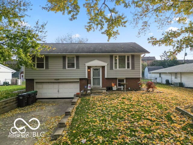 bi-level home featuring a garage and a front yard