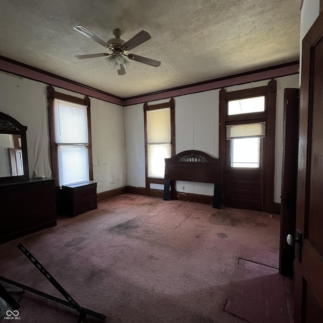 unfurnished bedroom featuring light carpet, ceiling fan, and a textured ceiling