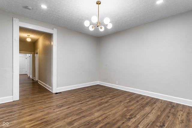 unfurnished room with dark wood-type flooring, a chandelier, and a textured ceiling