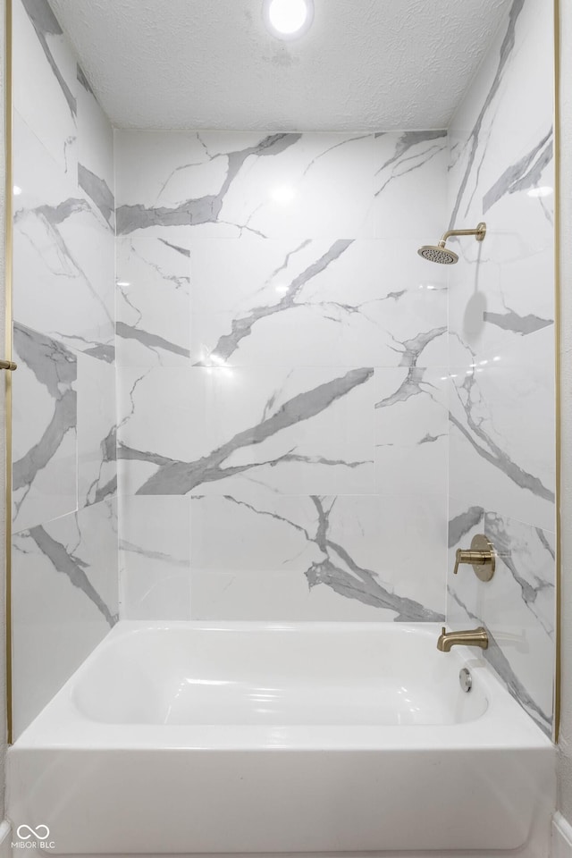 bathroom featuring tiled shower / bath and a textured ceiling