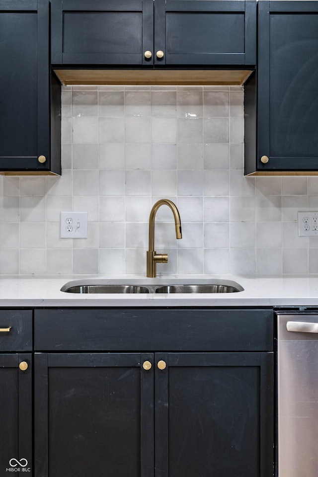 kitchen with blue cabinets, dishwasher, sink, and backsplash