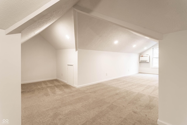 bonus room with a wall mounted air conditioner, carpet, a textured ceiling, and vaulted ceiling with beams