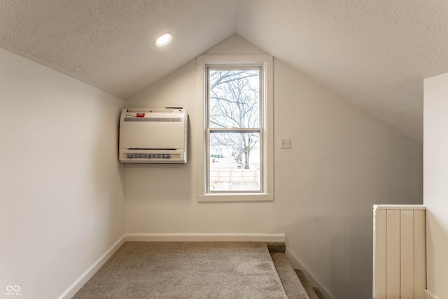 bonus room featuring heating unit, carpet floors, vaulted ceiling, and a textured ceiling