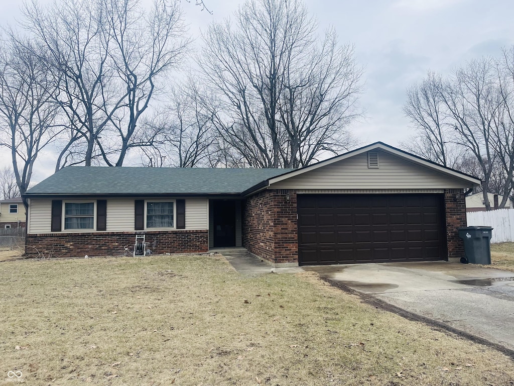 single story home featuring a garage and a front yard