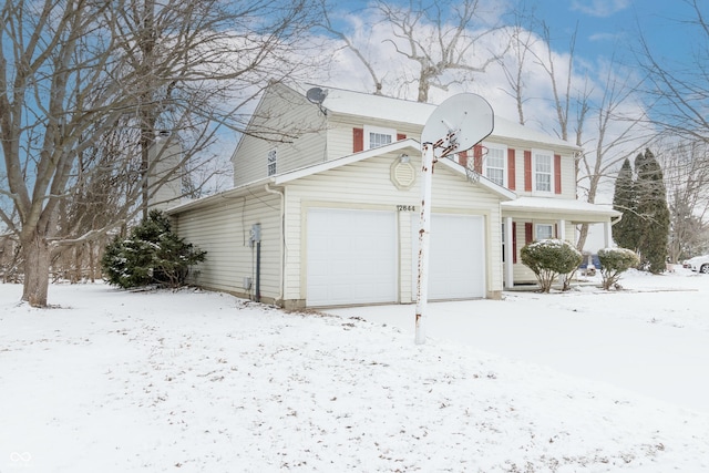 snow covered property featuring a garage