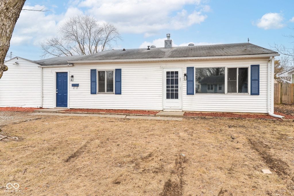 rear view of property with a lawn