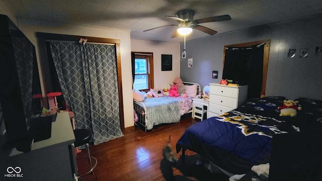 bedroom with dark hardwood / wood-style floors and ceiling fan