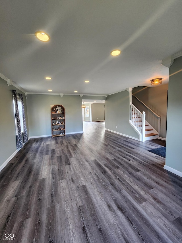 unfurnished living room with dark wood-type flooring and ornamental molding