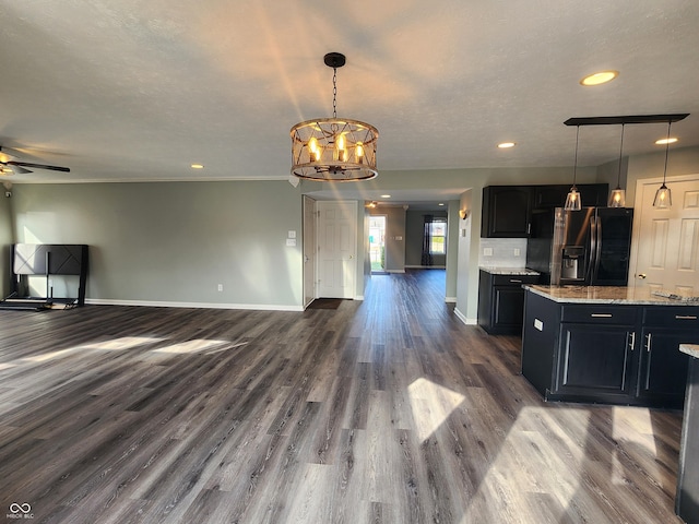 kitchen featuring stainless steel fridge with ice dispenser, ceiling fan with notable chandelier, dark wood-type flooring, and hanging light fixtures