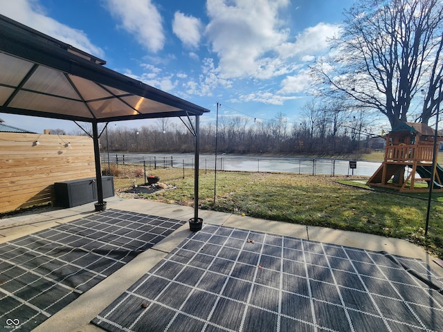 view of patio with a playground and a water view