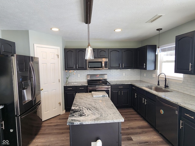 kitchen with stainless steel appliances, decorative light fixtures, dark hardwood / wood-style flooring, and sink