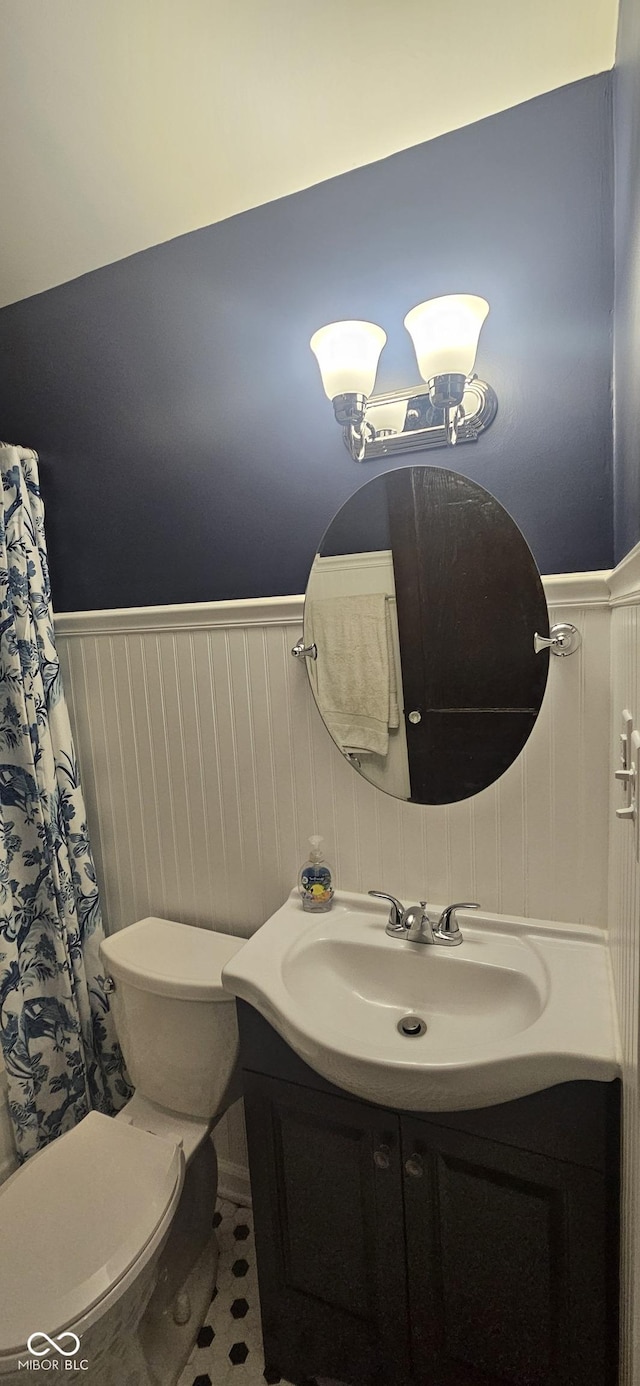 bathroom featuring vanity, toilet, and wainscoting