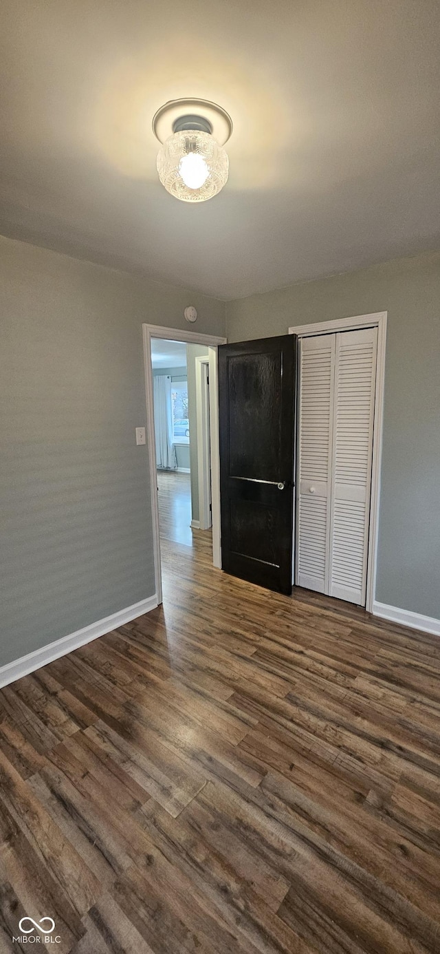 interior space with baseboards and dark wood-style flooring