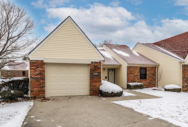 ranch-style house with a shingled roof, brick siding, and an attached garage