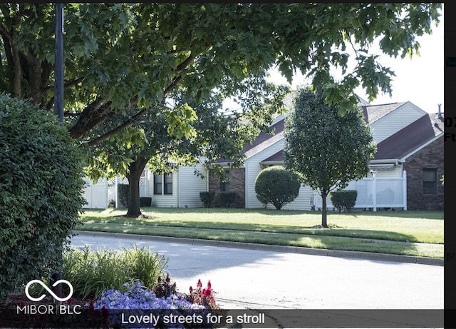 view of property hidden behind natural elements with a front yard