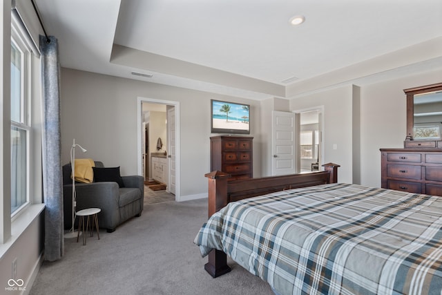 bedroom with connected bathroom and light colored carpet